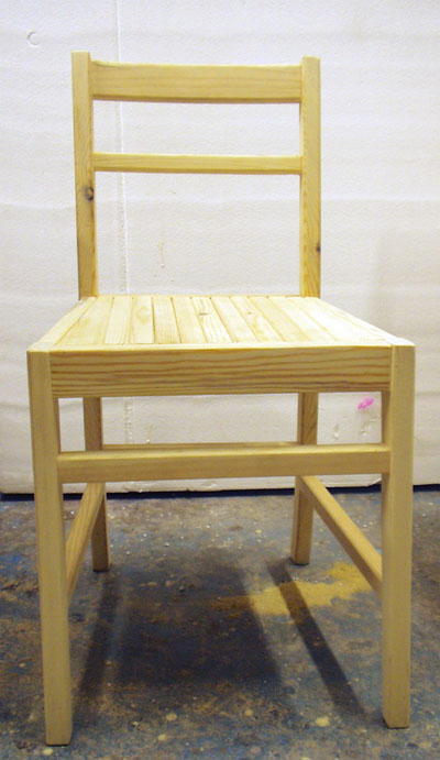 Front view of a pale coloured simple wooden chair