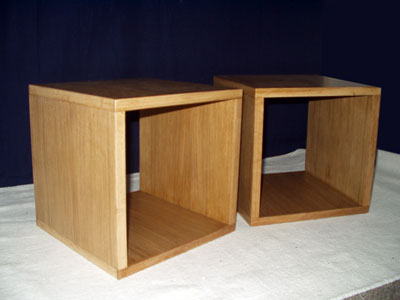 Side view of a pair of bedside tables in the form of a cube with open back and front