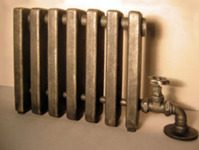 Front view of a old-fashioned radiator with a wheel-valve on the right side
