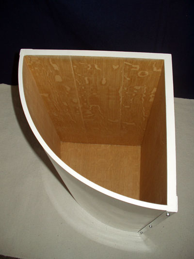 Top view of a curved white washing basket showing the oak vebeered interior