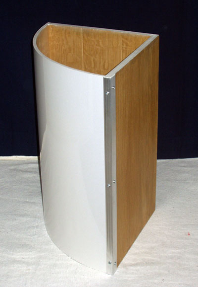 Side view of a curved white washing basket showing aluminium trim and oak-veneered sides